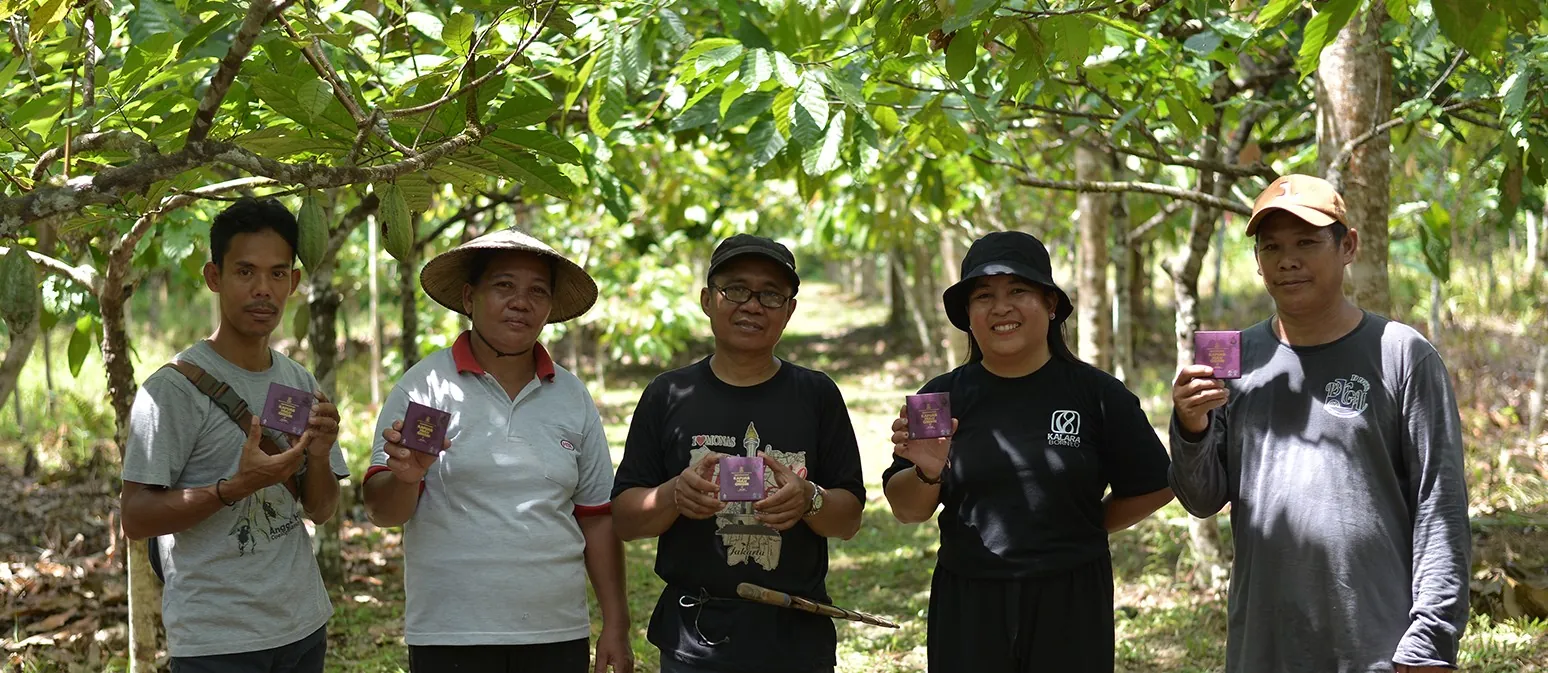 Founder Kalara Borneo bersama empat petani mitra di kebun kakao Kapuas Hulu, masing-masing memegang batang cokelat Kalara.